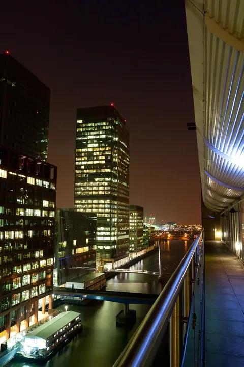 London docklands office towers lit up at night beside the water